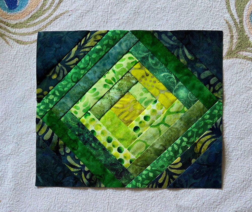 Small on point log cabin block in many shades of green.