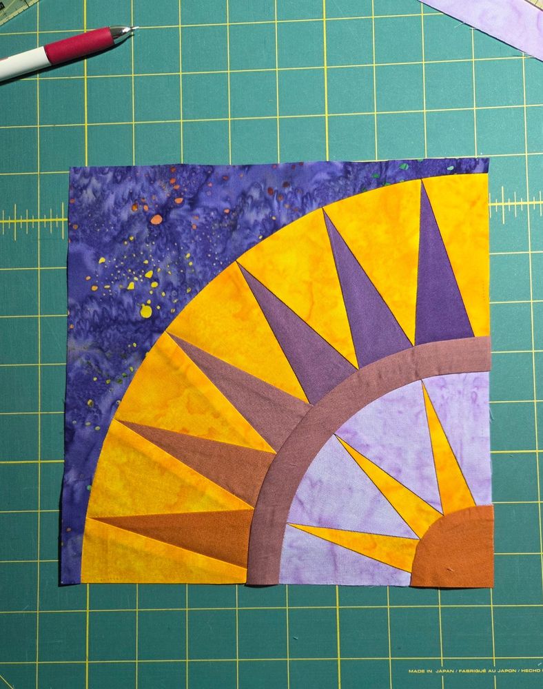 New York Beauty quilt block of purple, rust, and golds. 