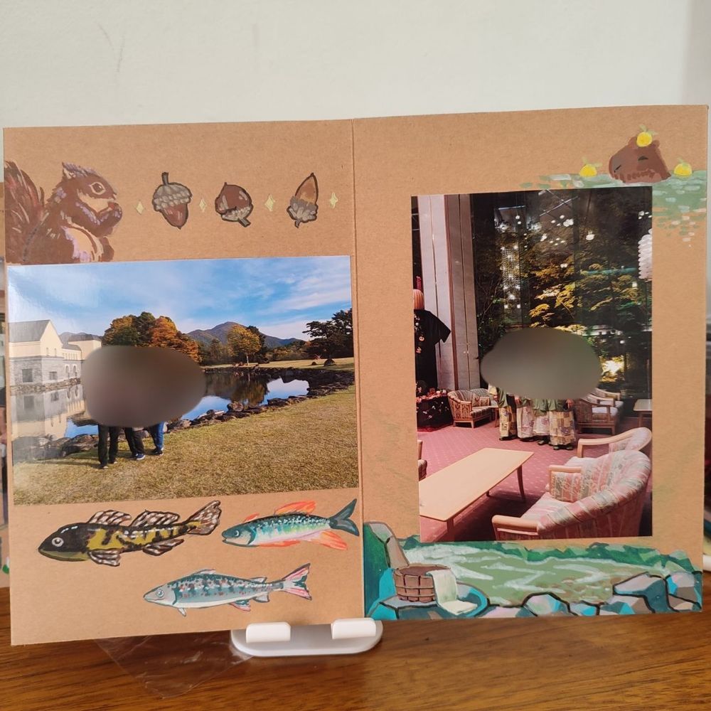 Página 1: Scrapbook, com desenho de esquilos, nozes, peixes de lago doce do Japão, e uma foto colada ao centro.
Página 2: Scrapbook ilustrado com águas termais, e capivara com yuzu na cabeça, e uma foto colada ao centro.