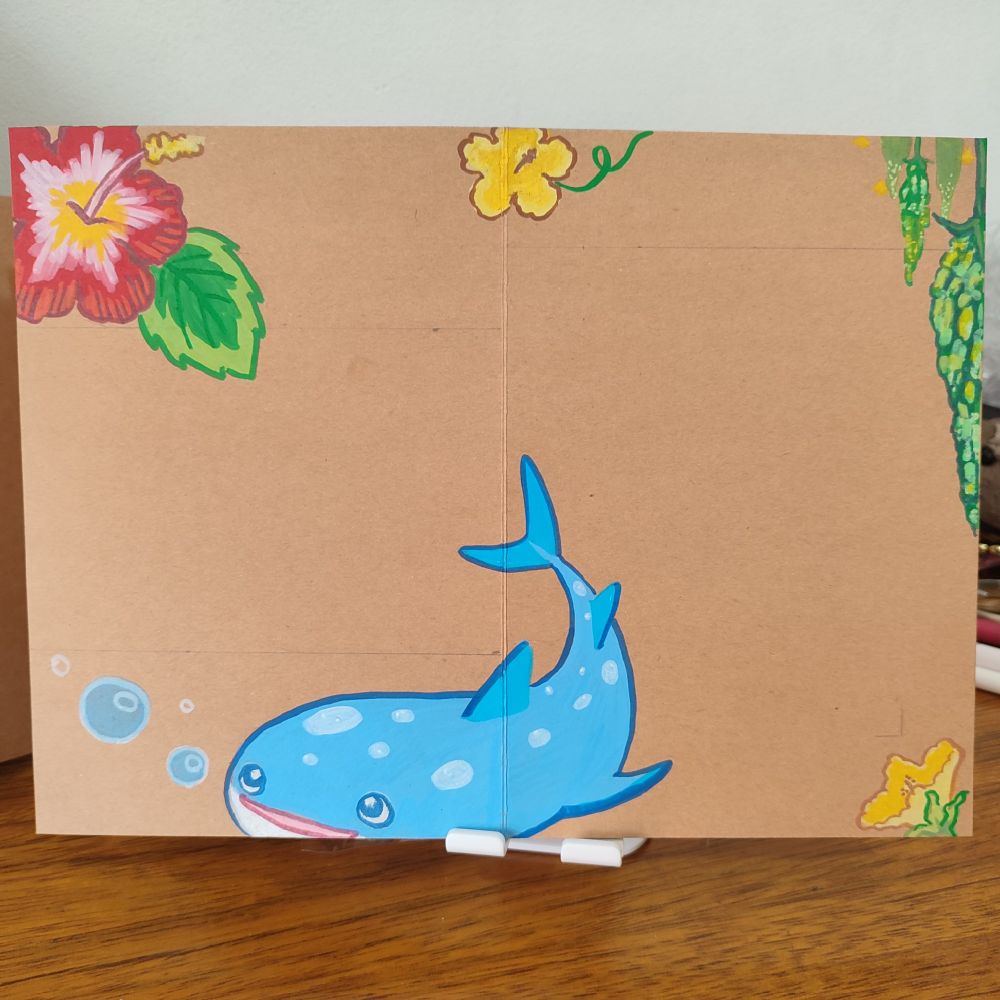 Página de scrapbook com ilustrações de hibiscos, goya/nigauri/melão de são caetano, e um tubarão-baleia de okinawa