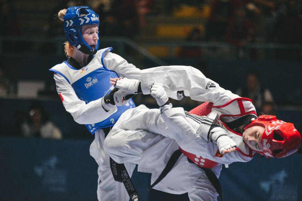 Josipa Kafadar in a blue taekwondo uniform kicking an opponent in red 