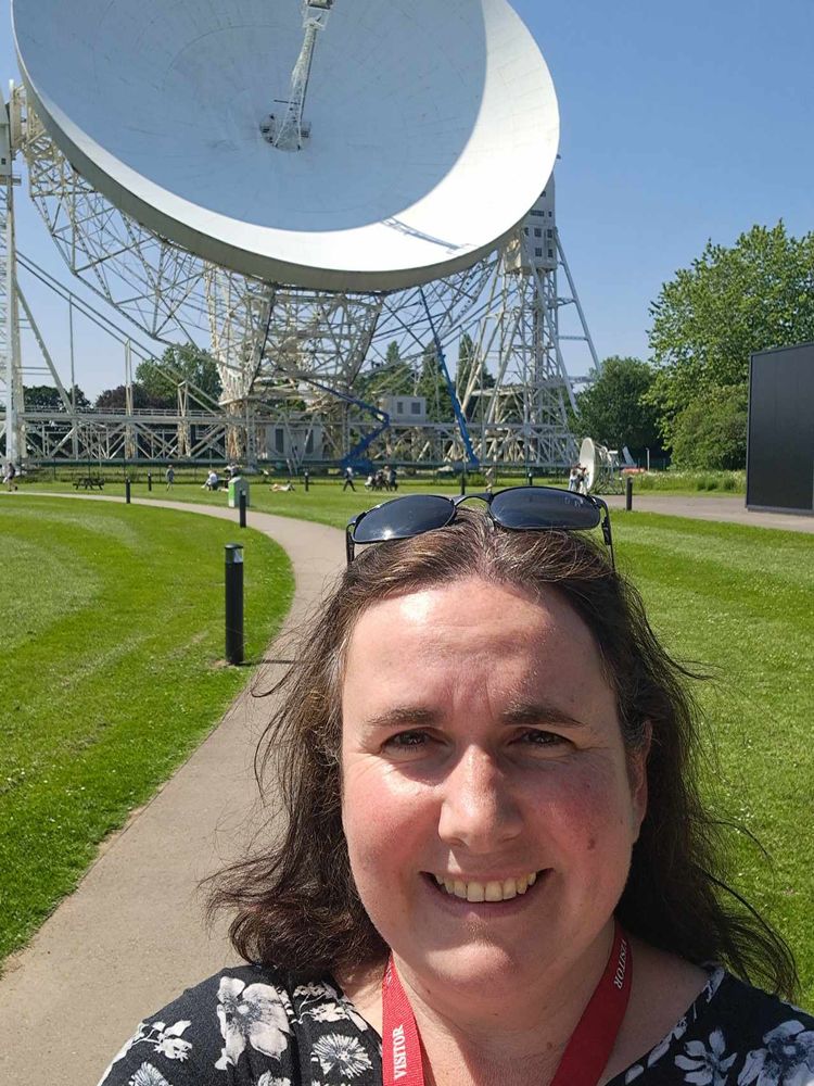 Jen on a sunny day in front of the Jodrell Bank radio telescope.