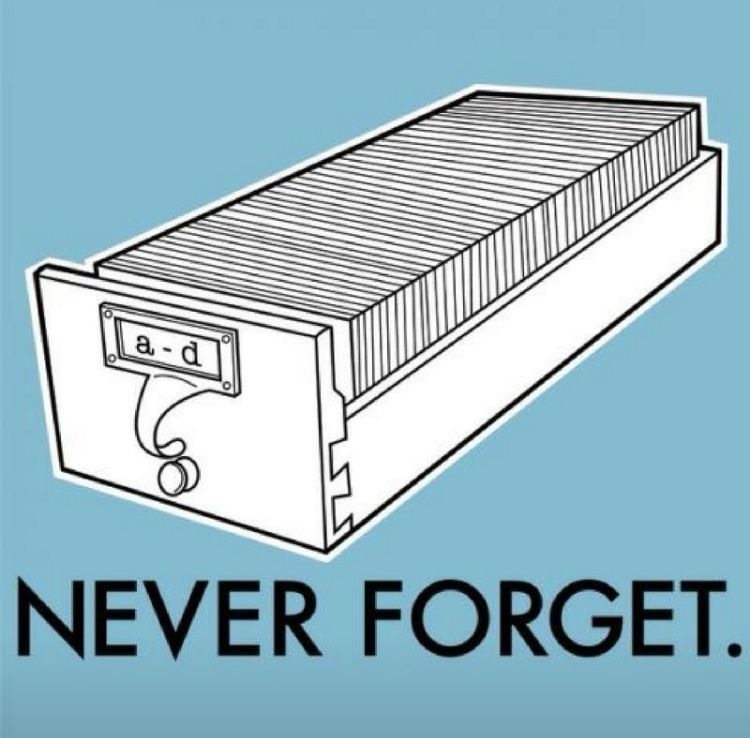 An illustration of a library card catalog drawer labeled “a-d,” with the caption “NEVER FORGET.”