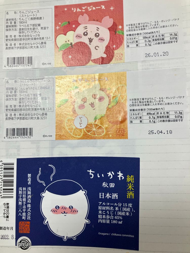 ノートにドリンクのラベル上から3枚貼ってある。カニ爪を頭につけたキャラ、シーサー、くりまんじゅうのようなキャラ