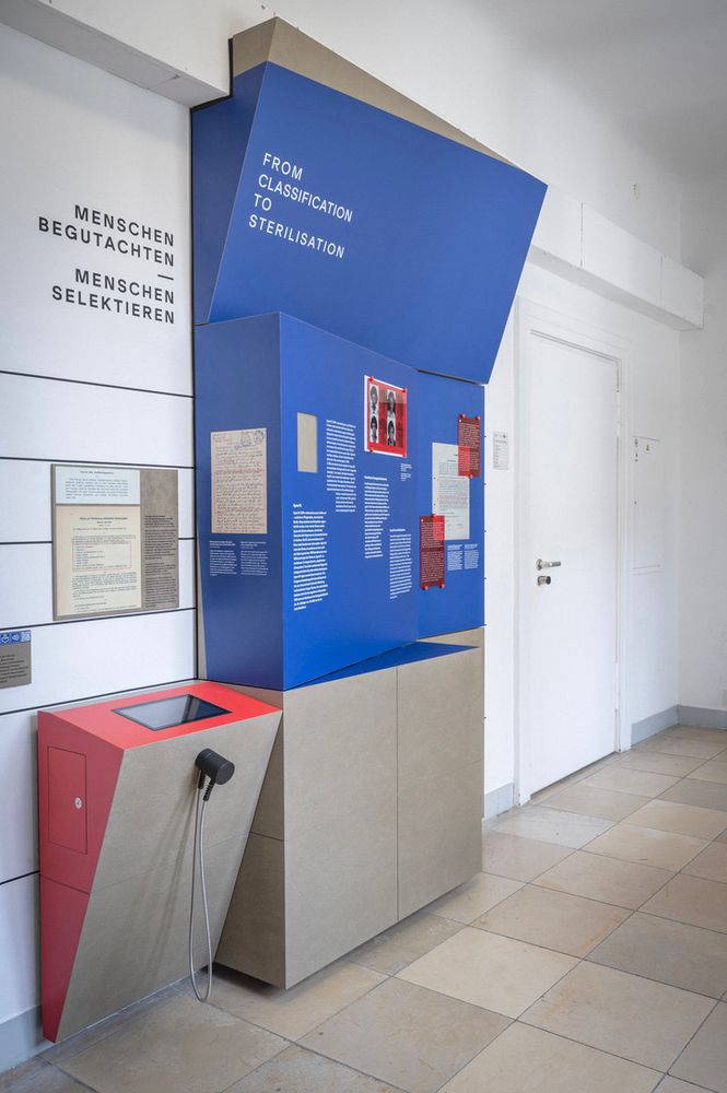 Eine Ausstellungsstation in einem Flur, mit dem Titel "Menschen begutachten, Menschen selektieren".