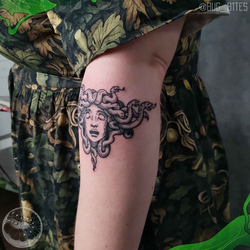 A woodcut style linework tattoo of a Medusa head. The placement is at the top of the forearm. 