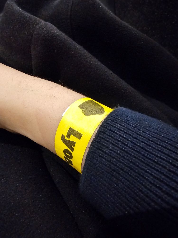 Photo d'un poignet avec le bracelet d'accès "LyonJS 100e édition"