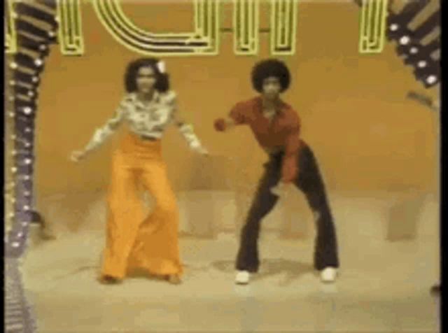 a man and a woman are dancing on a stage in front of a sign that says ' i love you ' .