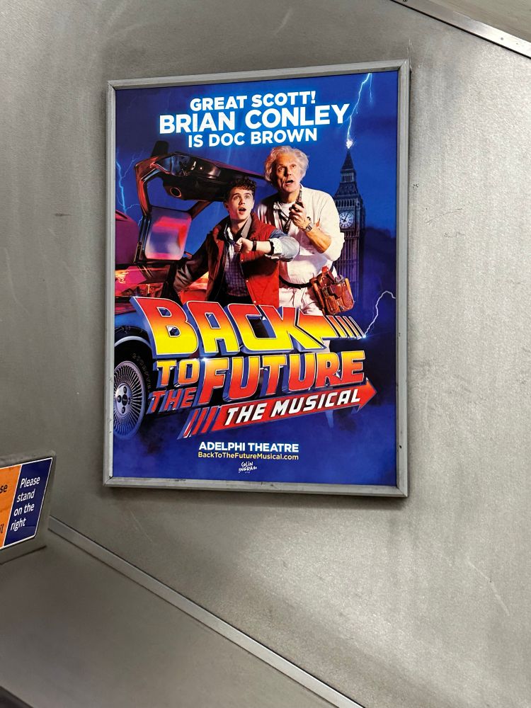 Pic of Back to the Future poster taken going down escalator on the London Underground. Described Brian Conley as Doc Brown