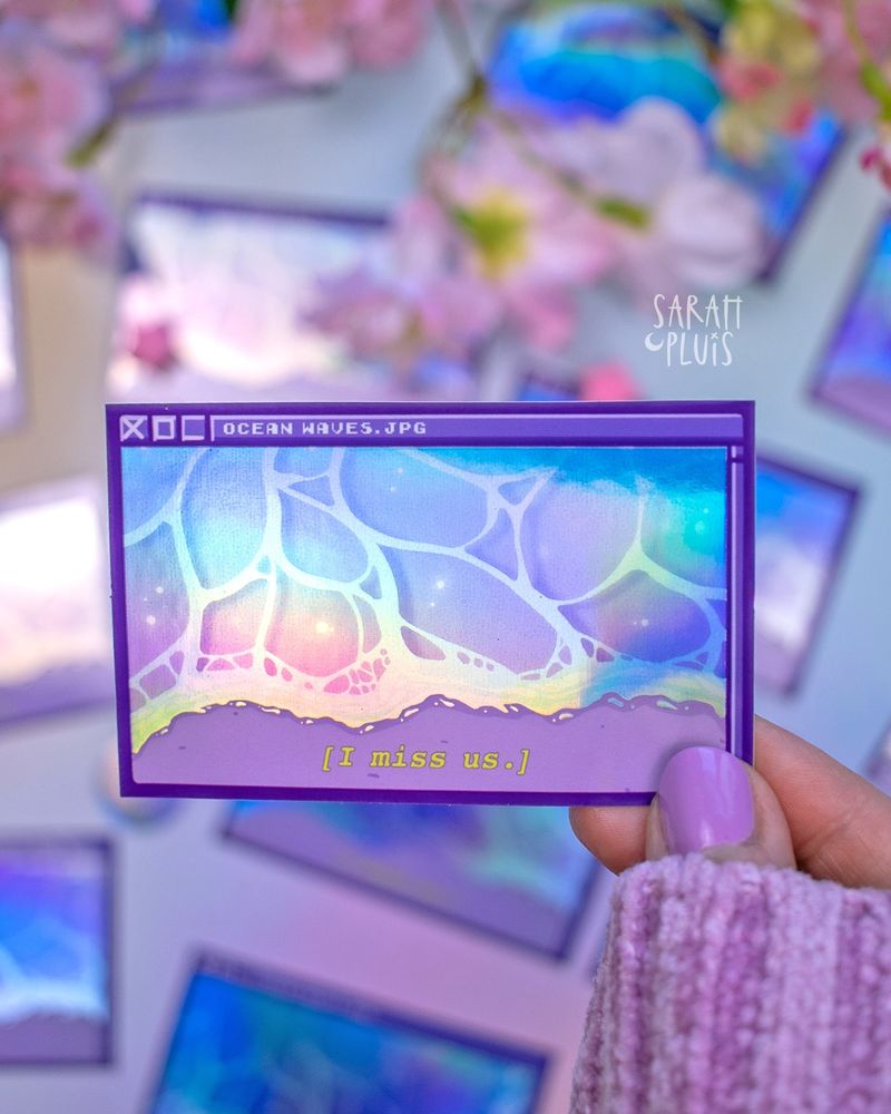 Eine Hand hält einen holografischen Sticker.