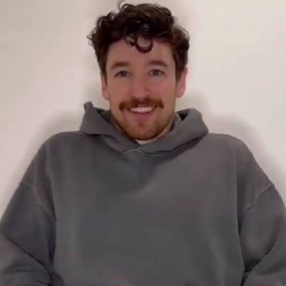 holenextdoor in a grey hoodie smiling