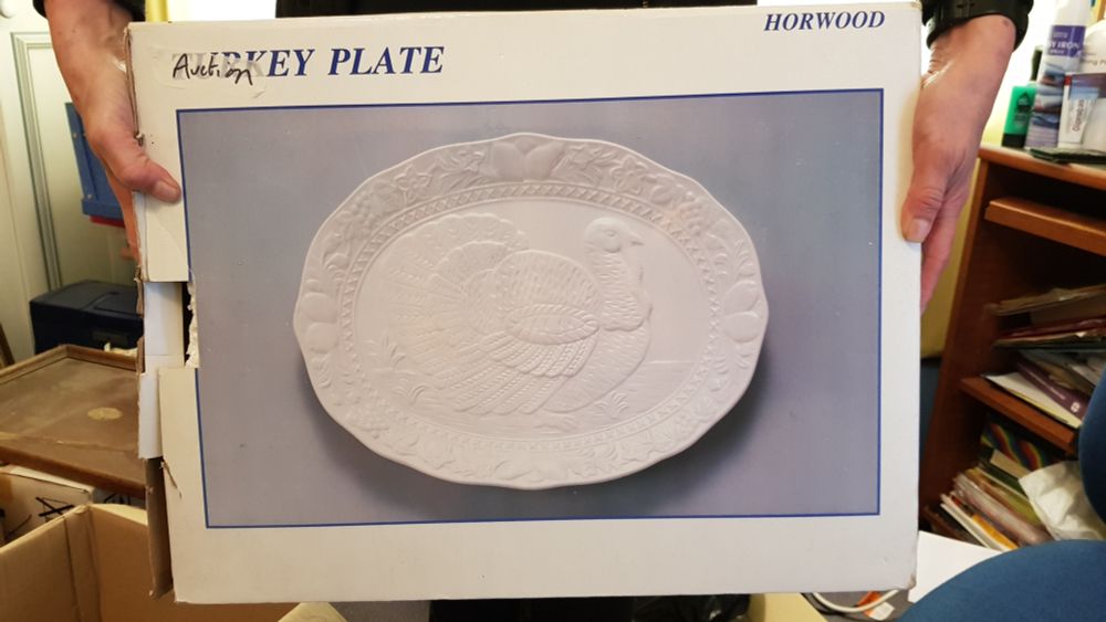 A photograph of a mahoosive box, which contains a giant white ceramic turkey platter, big enough to fit a sacrificial primary schooler on.