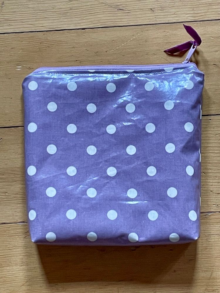 Ein Nessesser in Spezialgrösse. Der Stoff ist gepunktet, es hat einen Reissverschluss mit einem kleinen Samtband dran. 