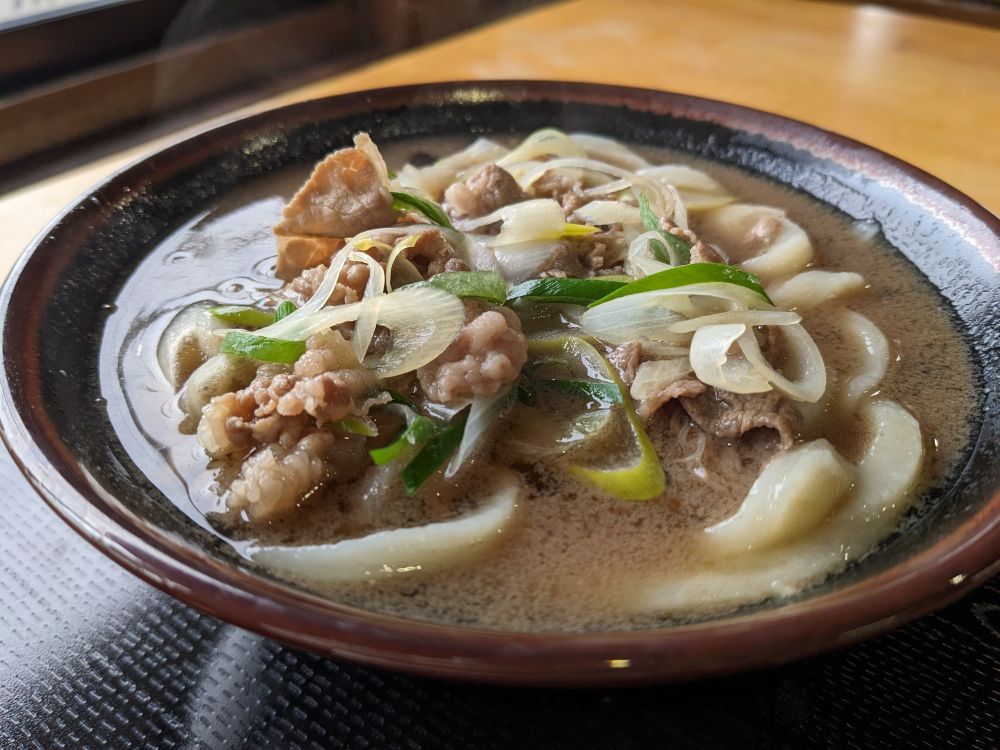 肉うどんの写真。温かい湯気がでている。甘めのお肉が美味しい。