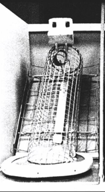 black & white photo of Dr. Harry Harlow’s “wire mother” from his maternal love deprivation experiments on monkeys, a wireframe cylinder with a rudimentary facsimile of a primate head affixed on top. 