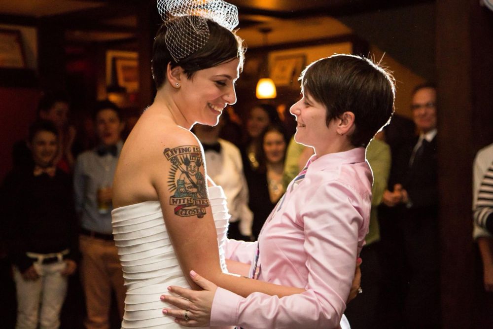 Two people at a wedding gaze at each other while dancing. 