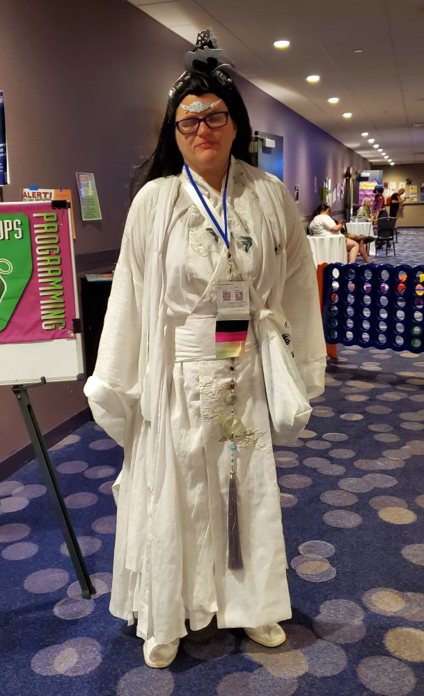A cosplayer in the all white robes of the Lan clan from The Untamed.