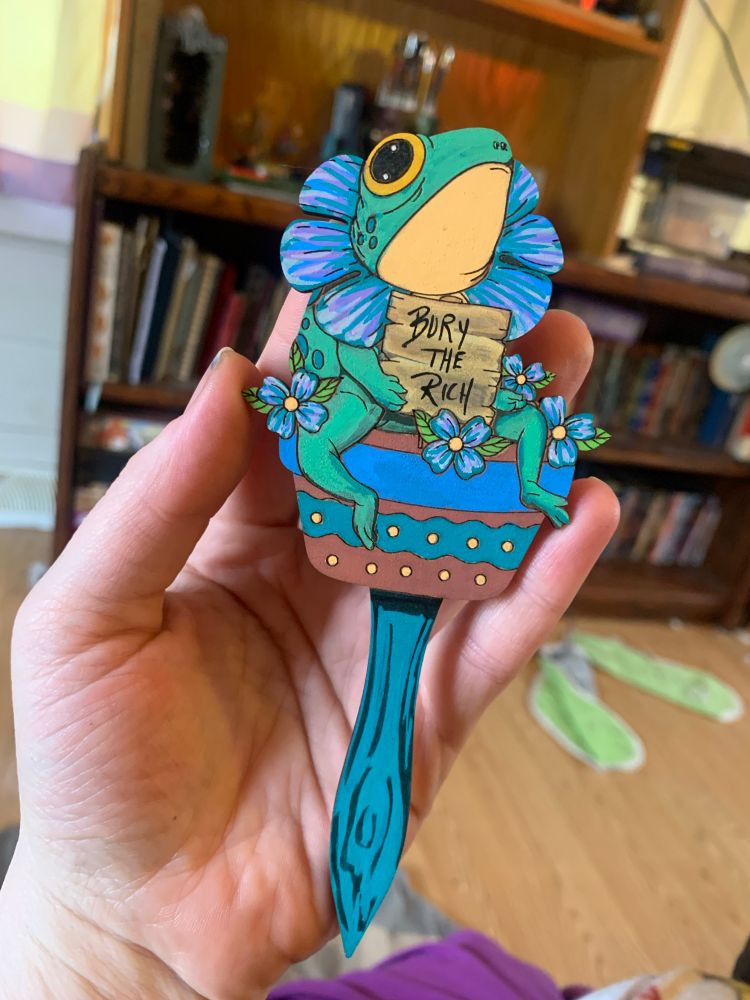 Bury the Rich, plant stake, adorable frog sitting in a plant with a flower on his head, dissension 