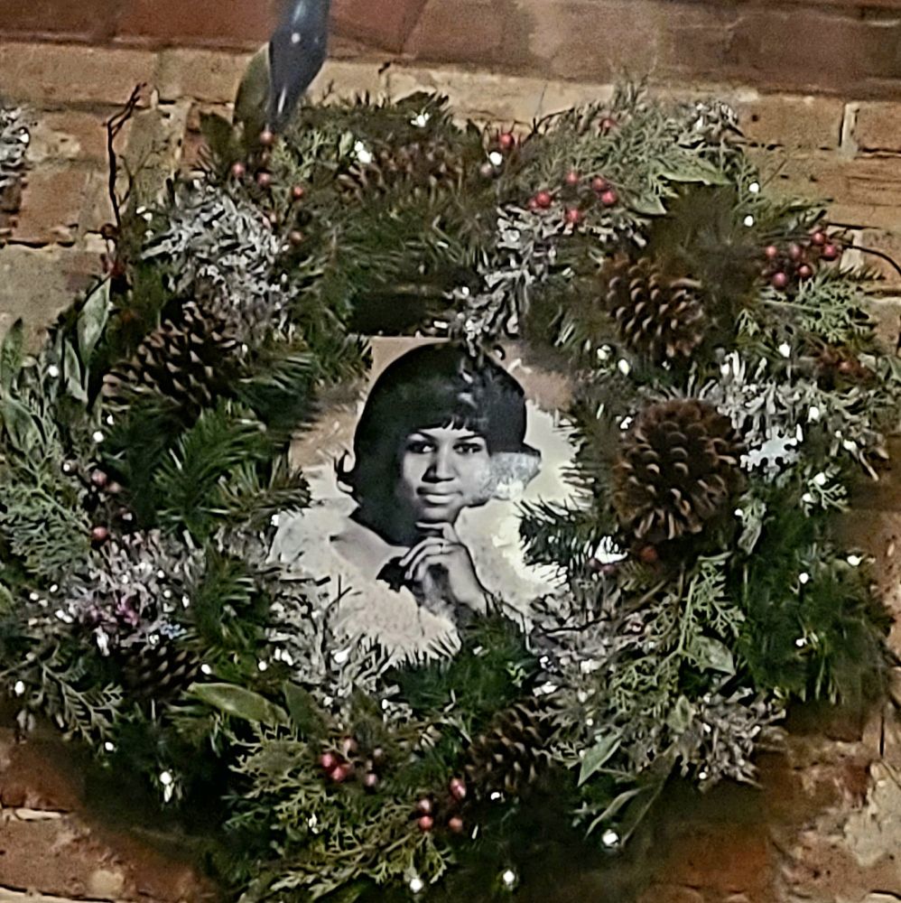 A Christmas wreath with a picture of Aretha in the center, at Jewel of the South