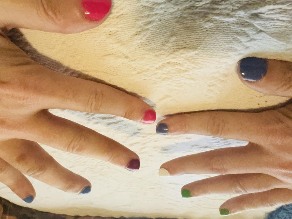 A photo of my nails against a white bedspread. On the left are bisexual flag colors; on the right are genderqueer flag colors. 