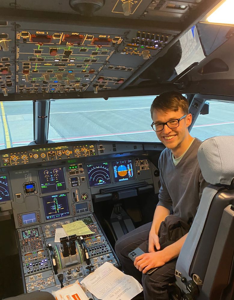 A photo of me sat in one of the pilot's chairs in an aeroplane cockpit.
