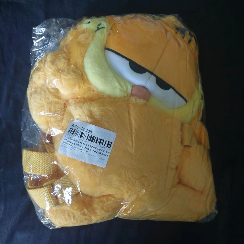 A plush Garfield backpack vacuum sealed into a square. 