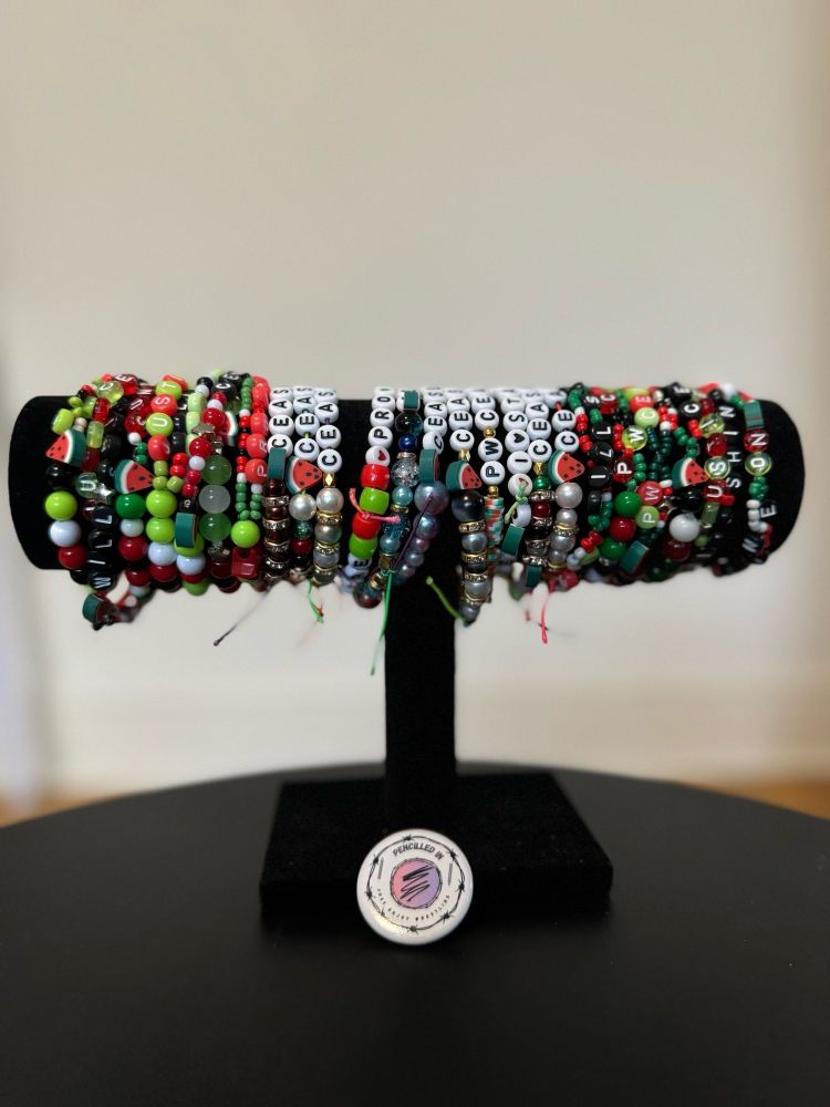A bracelet holder displaying an array of beaded friendship bracelets in the colours of the Palestinian flag 🇵🇸 