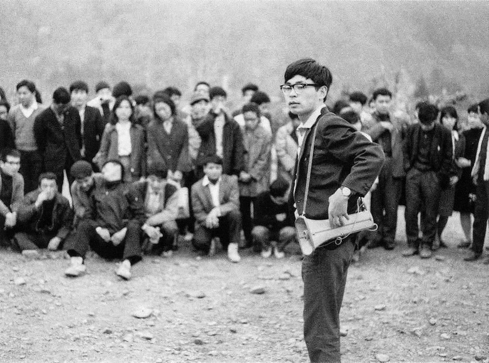 A photo of a young Hayao Miyazaki with a bullhorn leading a group of union animators 
