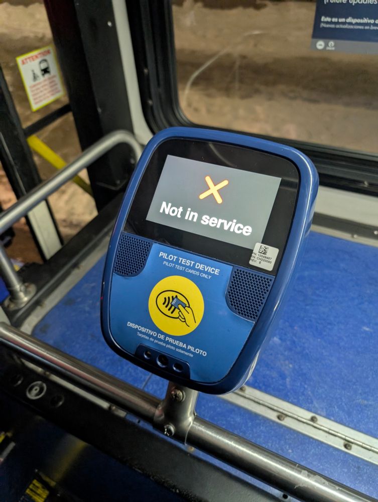 Pilot Ventra test device affixed to the railing inside a CTA bus