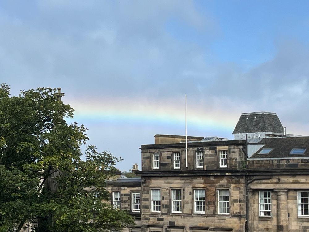Georgian buildings with a rainbow arcing over the roofs.