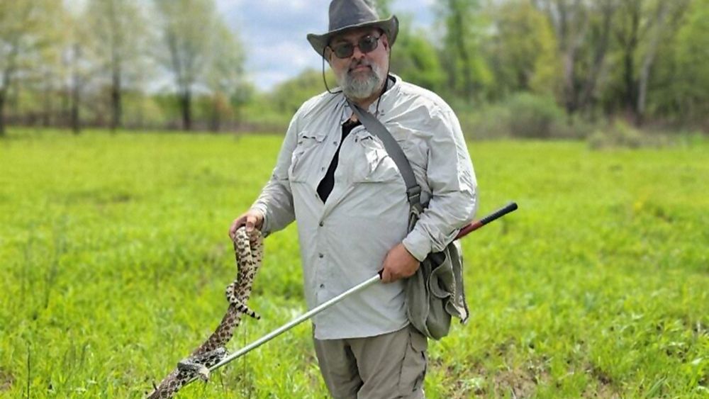 A man holding a snake.