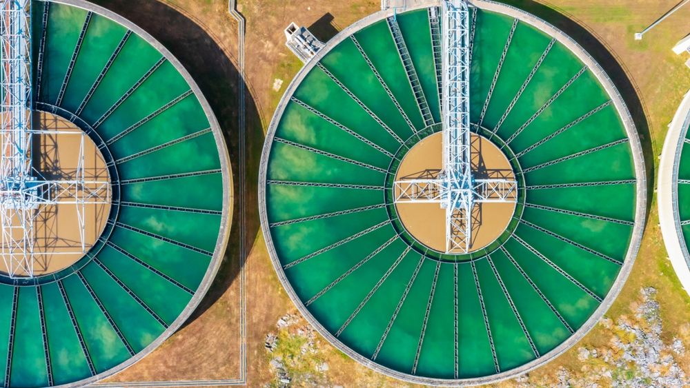 Aerial view of circular clarifier tank at a wastewater treatment facility.