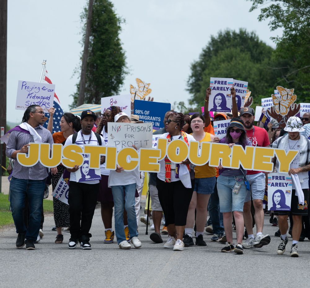The March as people hold a Justice Journey sign