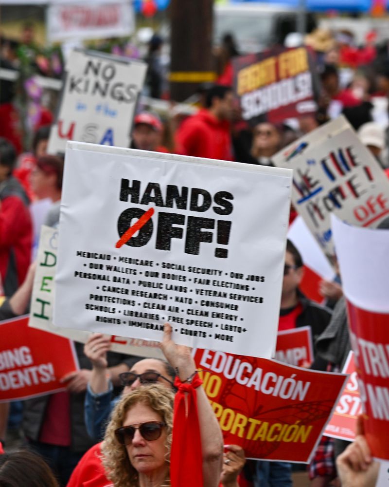 A crowd shot with a hands off sign