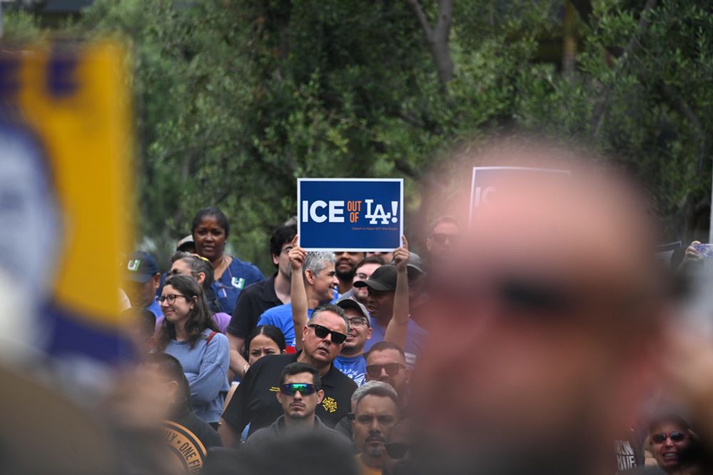 Crowded rally, with one attendee holding up a sign that says ICE out of LA.