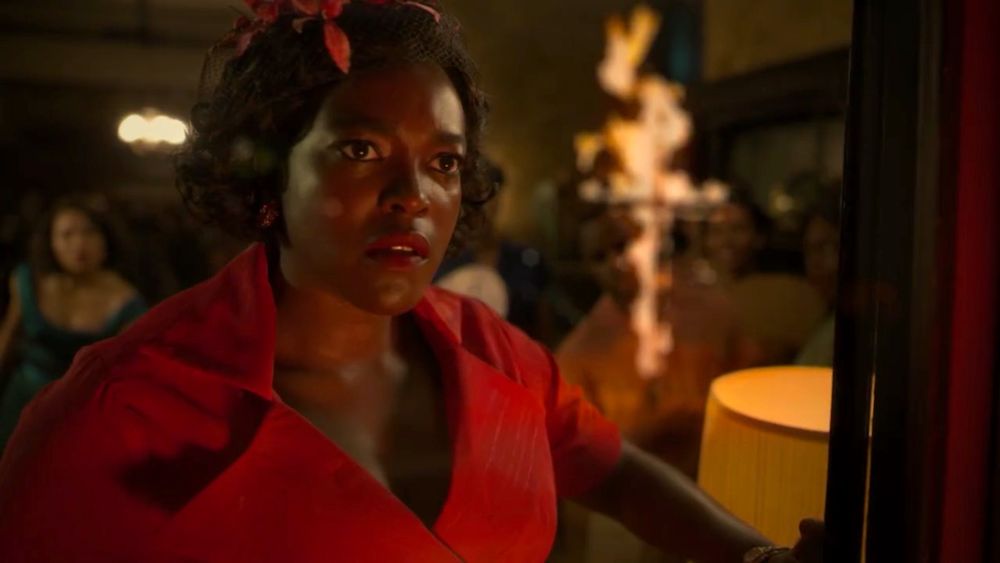 On the right, an image from the 2020 series LOVECRAFT COUNTRY in which Ruby, a Black woman in the 1950s dressed in red, stares out her window, a burning cross on her lawn visible in the reflection.