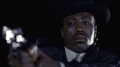 wesley snipes holding up a gun to shoot someone off screen with tears rolling down his face