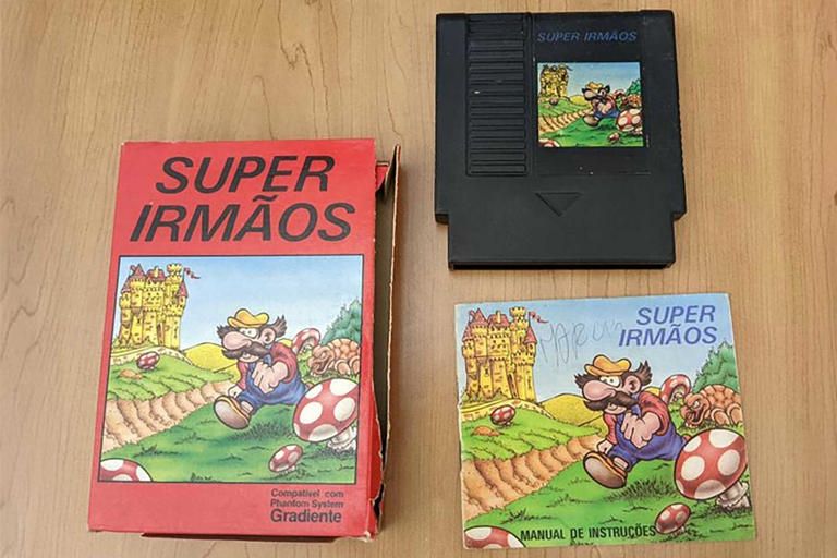 Cartucho do jogo Super Irmãos com caixa e manual. Na capa e manual o desenho de um bigodudo genérico de macacão jeans camisa vermelha, chapéu amarelo e bigode olivio-nietzscheano andando no gramado a céu aberto com castelo ao fundo, cogumelos gigantes e uma tartaruga com cara de más intenções na paisagem. 