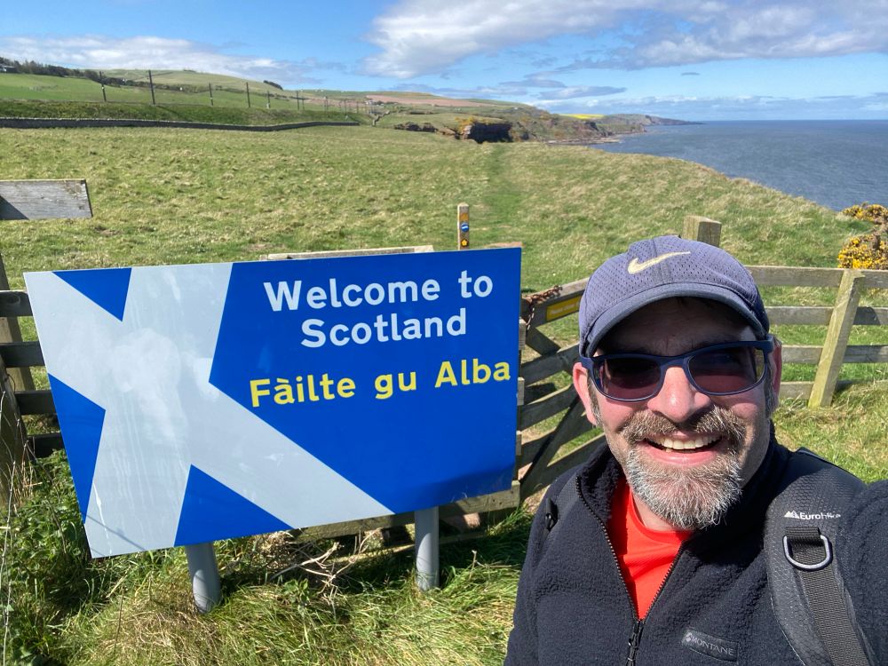 Dave stood next to the ‘Welcome to Scotland’ sign on the border. 
