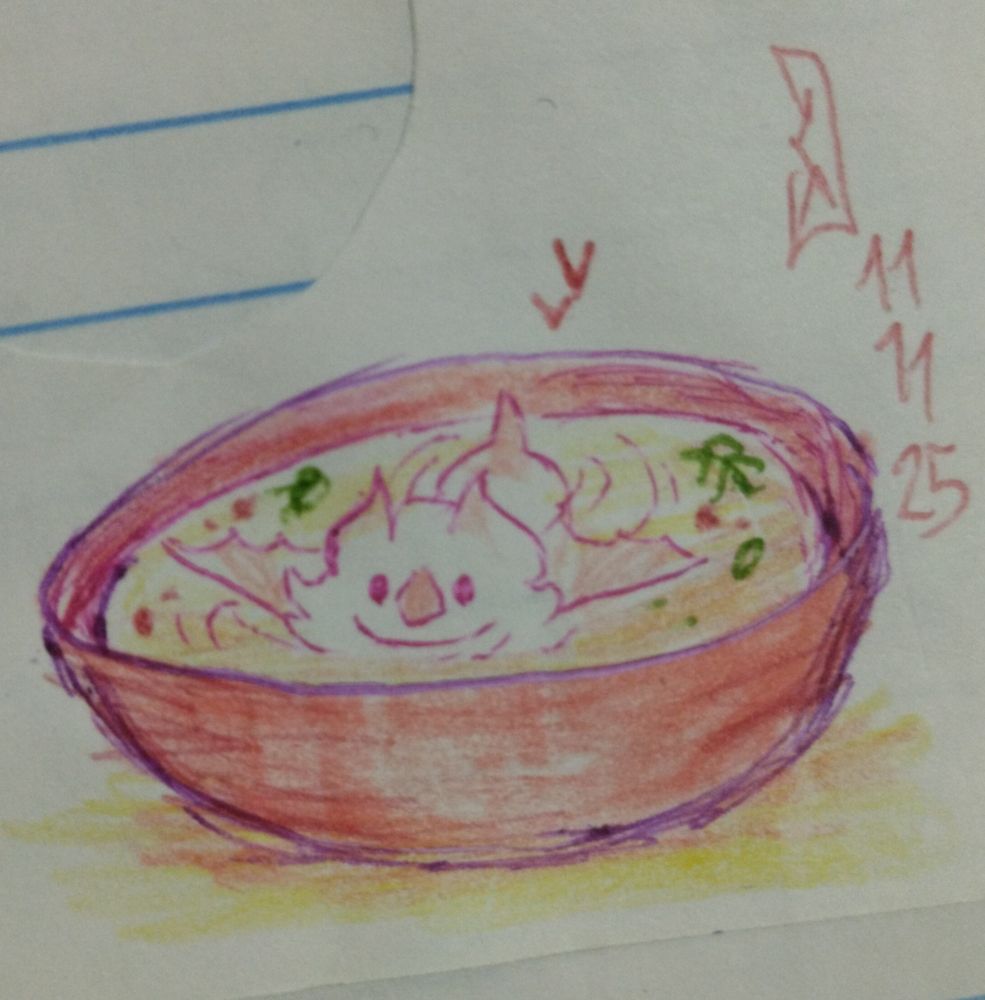 Um mini Aatto numa tigela de sopa. Ele parece relaxado e feliz.