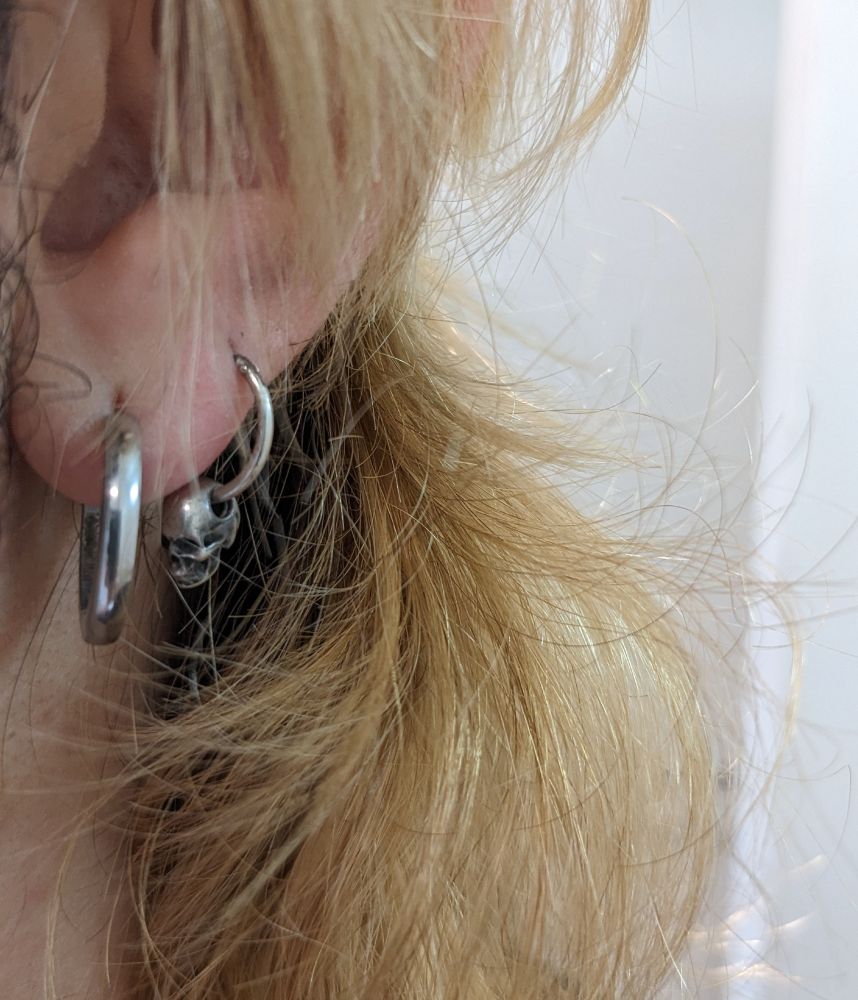 Closeup of a rad silver skull earring