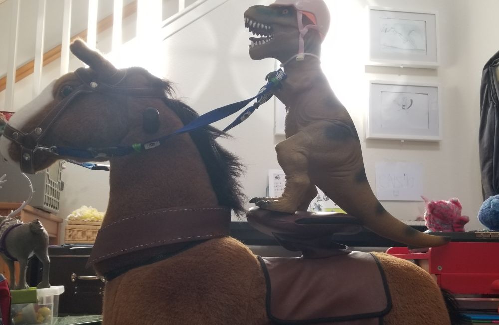 A t-rex in a pink helmet riding a horse.