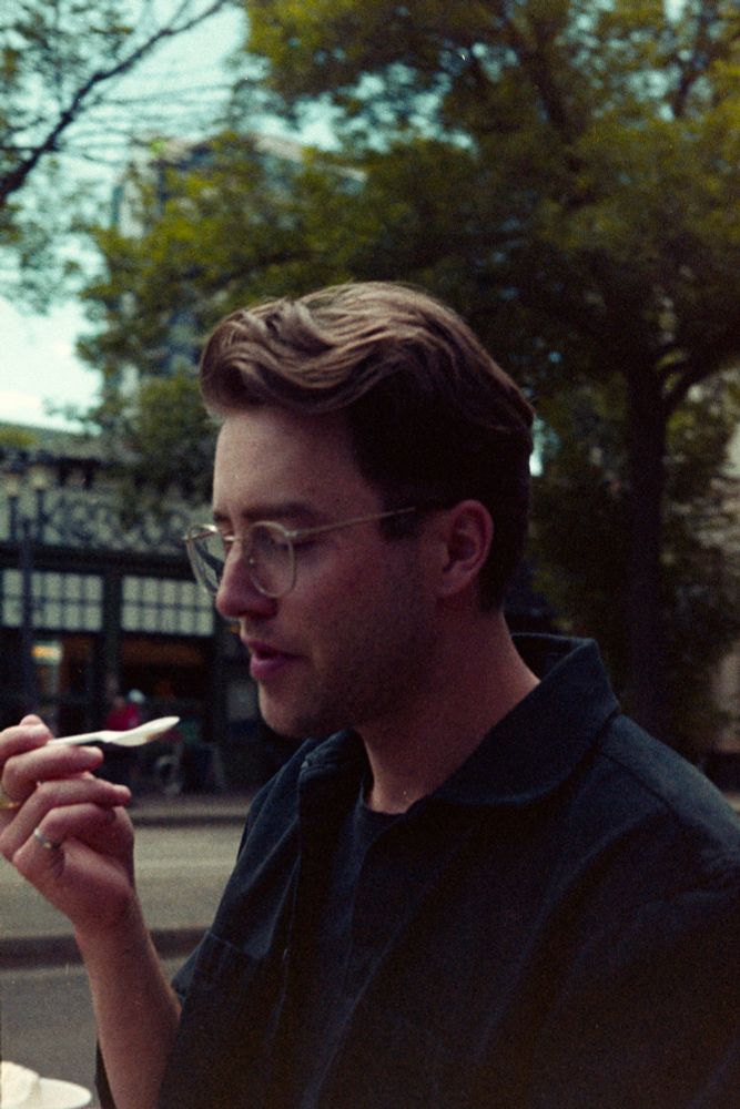 Colour film photo of a perfectly coiffed man eating a spoonful of ice cream on the street.

Photo by Jacy Eberlein, taken in Edmonton, Alberta on July 1st 2025. Taken with a Nikon F3 with the 50mm f1.4 AFD lens, and Kodak 400.