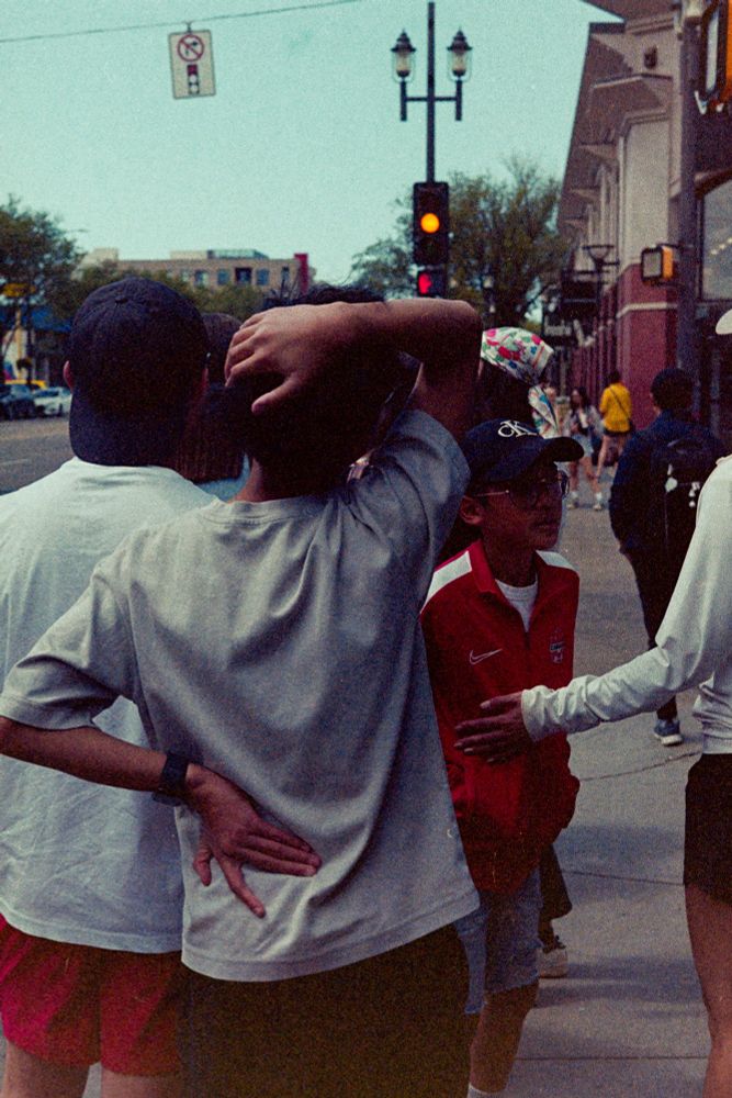 Colour film photo of a man from behind, waiting at the crosswalk. His arms twist in an interesting shape as he stretches.

Photo by Jacy Eberlein, taken in Edmonton, Alberta on July 1st 2025. Taken with a Nikon F3 with the 50mm f1.4 AFD lens, and Kodak 400.