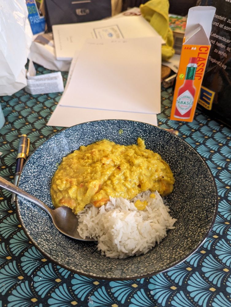 Dahl de lentilles corail et riz dans un bol bleu sur une nappe bleue