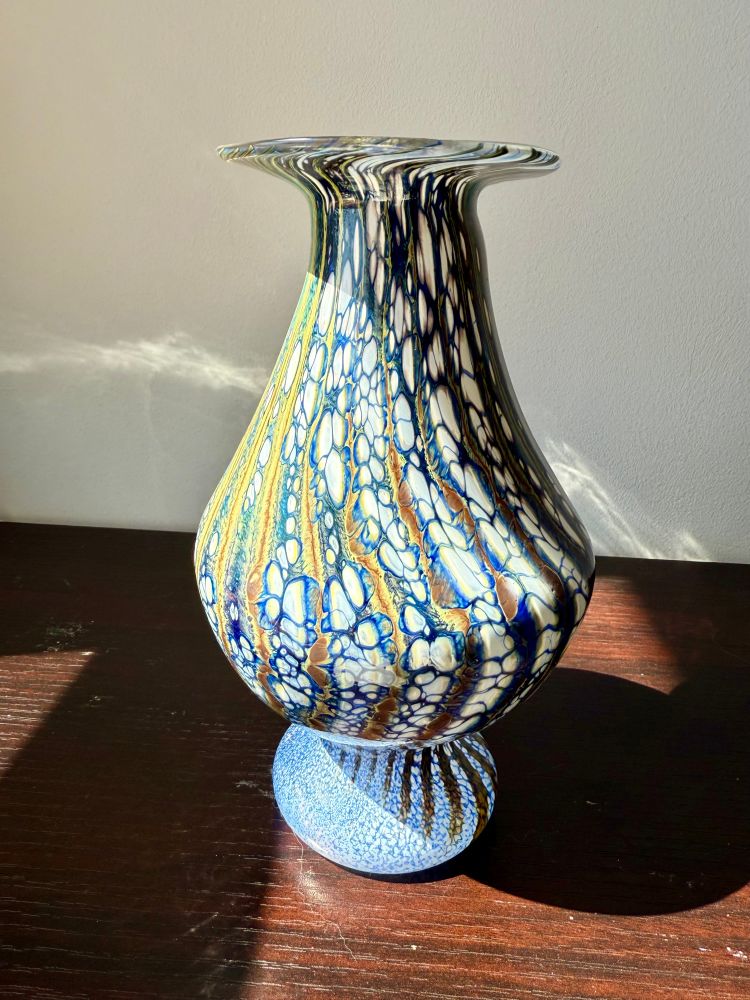 A blown glass vase with blue and white and gold