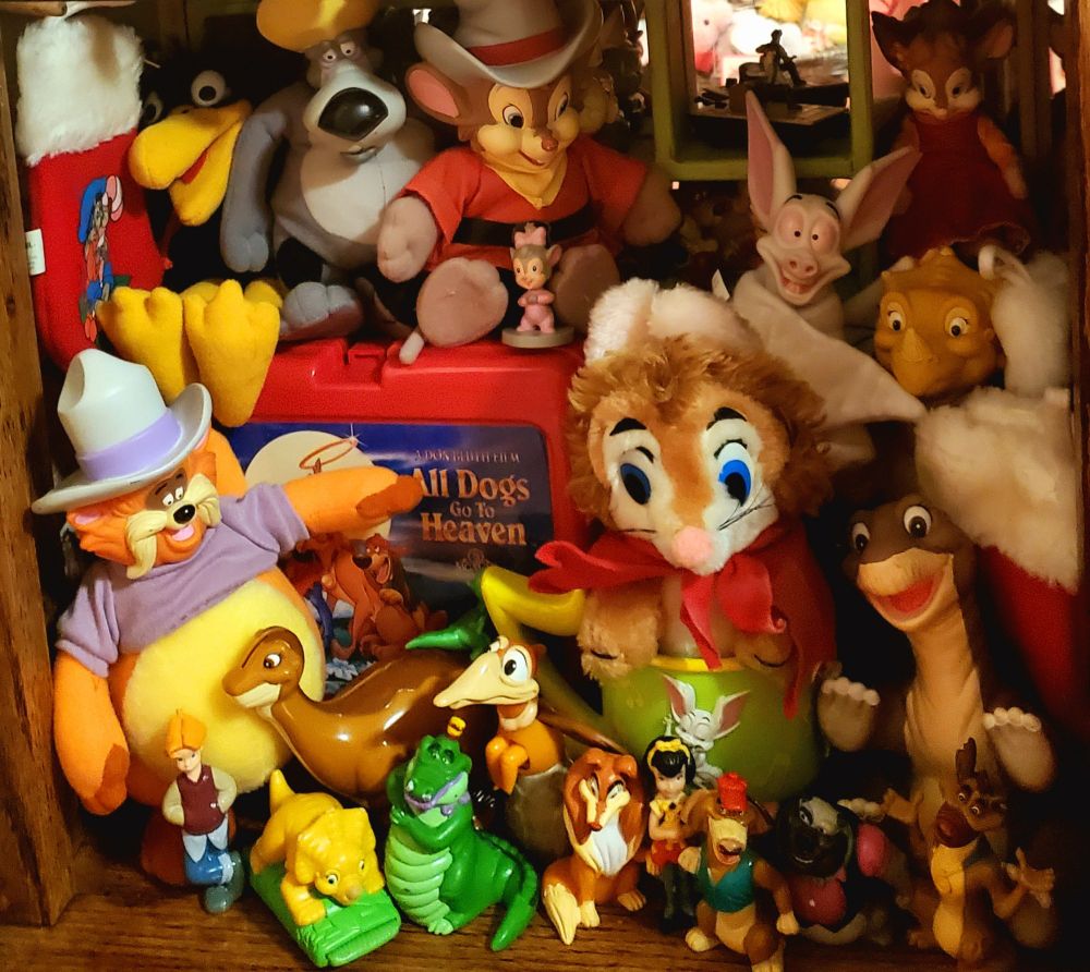 Mixture of plushies, figurines and other merchandise produced for Don Bluth Studios productions, including characters from "Secret of NIMH", "American Tail", "Land Before Time", "All Dogs go to Heaven" and "Anastasia".