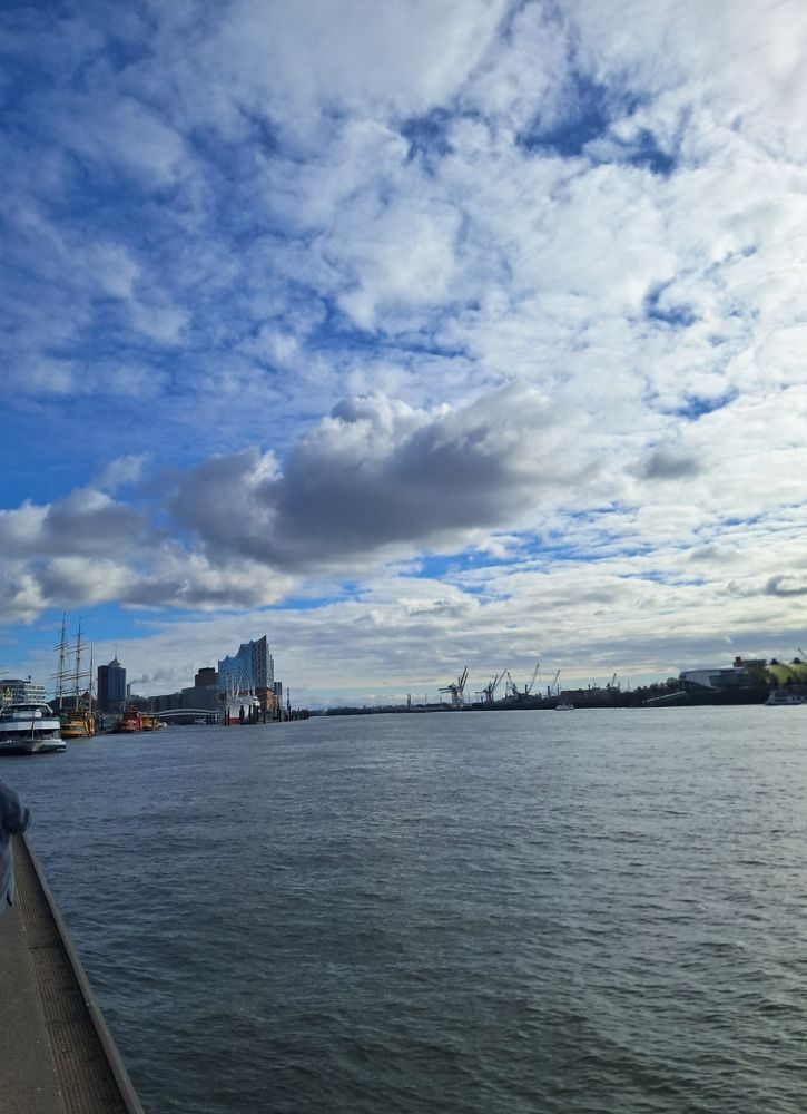 Looking down the Elbe from Landungsbrücken towards the Elbphilharmonie. Scattered clouds.