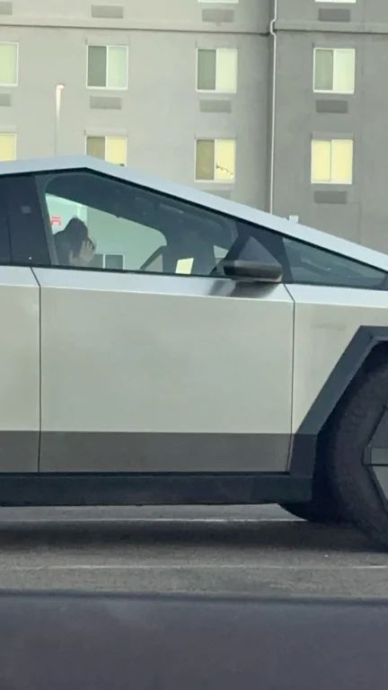 Woman sitting in a Cybertruck with her head in her hands
