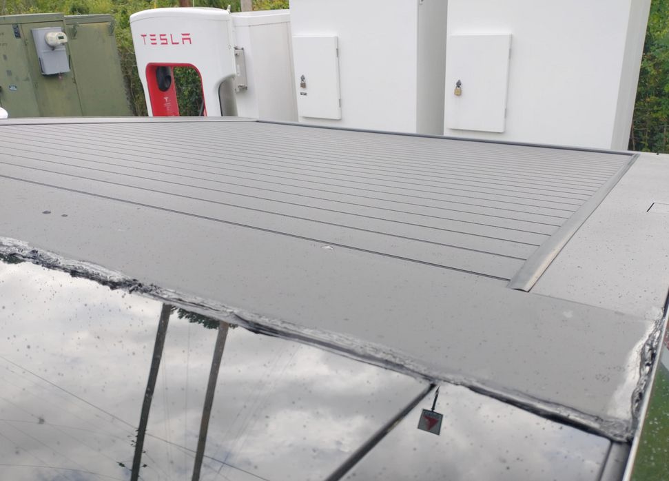 picture of the top of a cybertruck showing a poorly applied bead of black silicone about 15mm wide around the top cover of the 